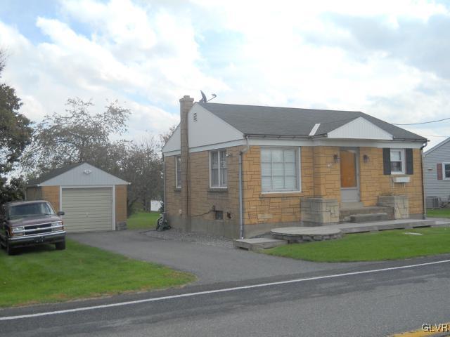 a front view of a house with a garden and plants