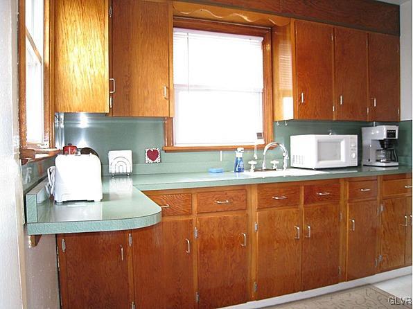 8368 Airport Road Bath, PA 18014 - Photo 3 of 10 a kitchen with stainless steel appliances granite countertop wooden cabinets a sink and a window