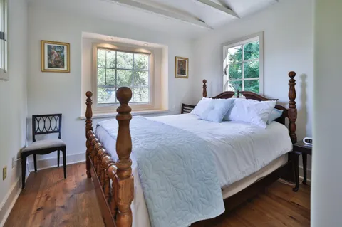 a bedroom with a bed and a large window