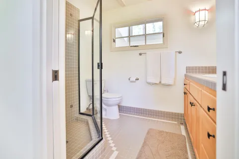 a bathroom with a tub mirror and toilet