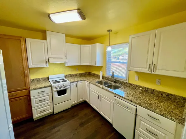 a kitchen with stainless steel appliances granite countertop a stove a sink and a refrigerator