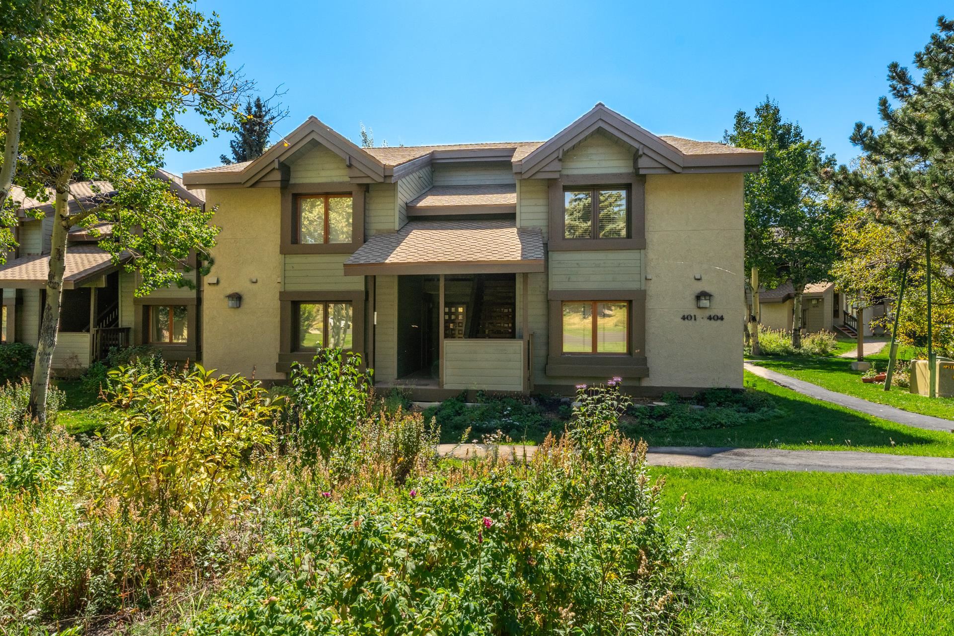 a front view of a house with yard and green space