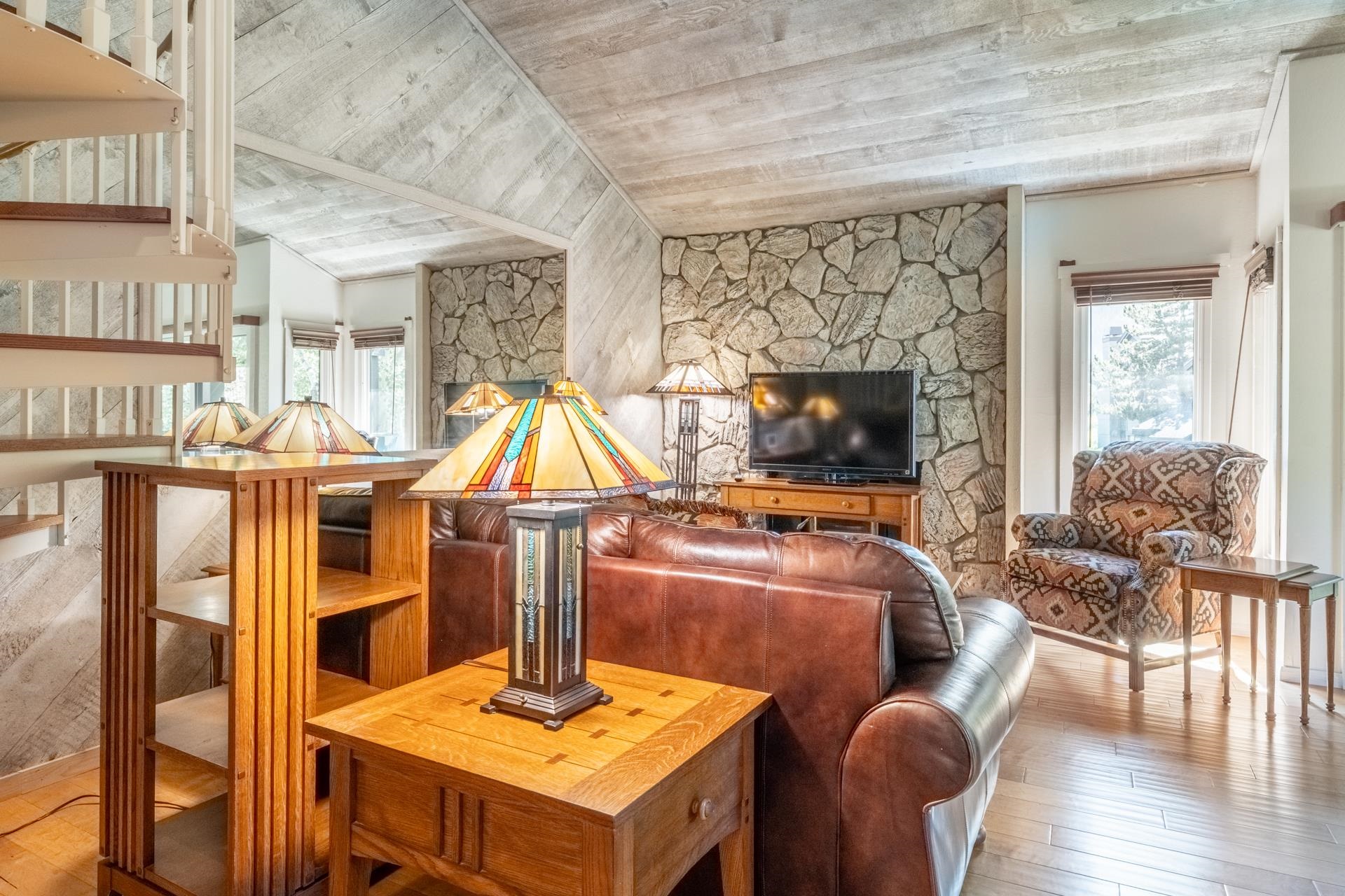 402 Snowcreek Road, Unit 402 Mammoth Lakes, CA 93546 - Photo 5 of 47 a living room with furniture a flat screen tv and a floor to ceiling window