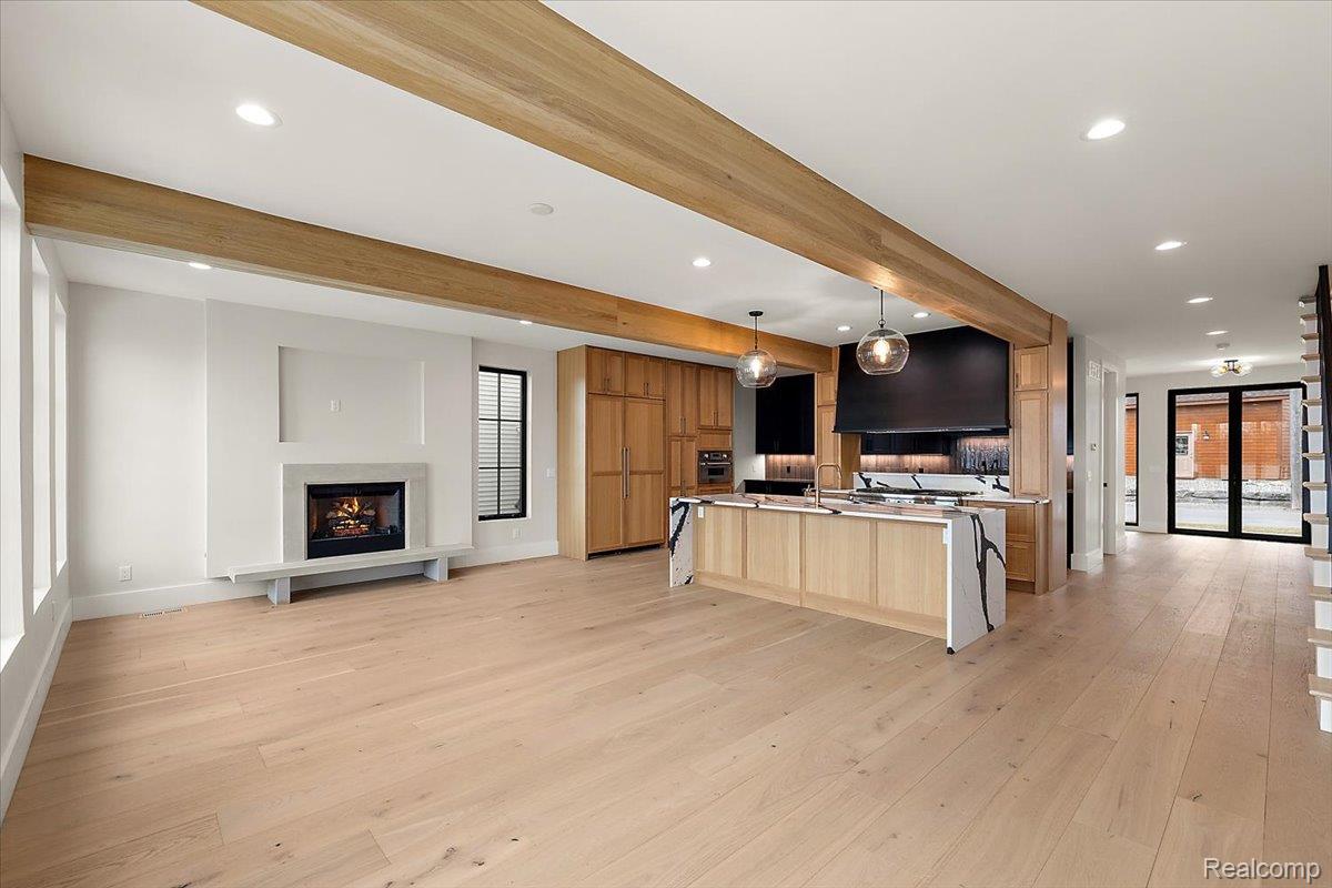 13459 Haddon Street Fenton, MI 48430 - Photo 82 of 84 Kitchen featuring open floor plan, a large island with sink, pendant lighting, light countertops, and beam ceiling