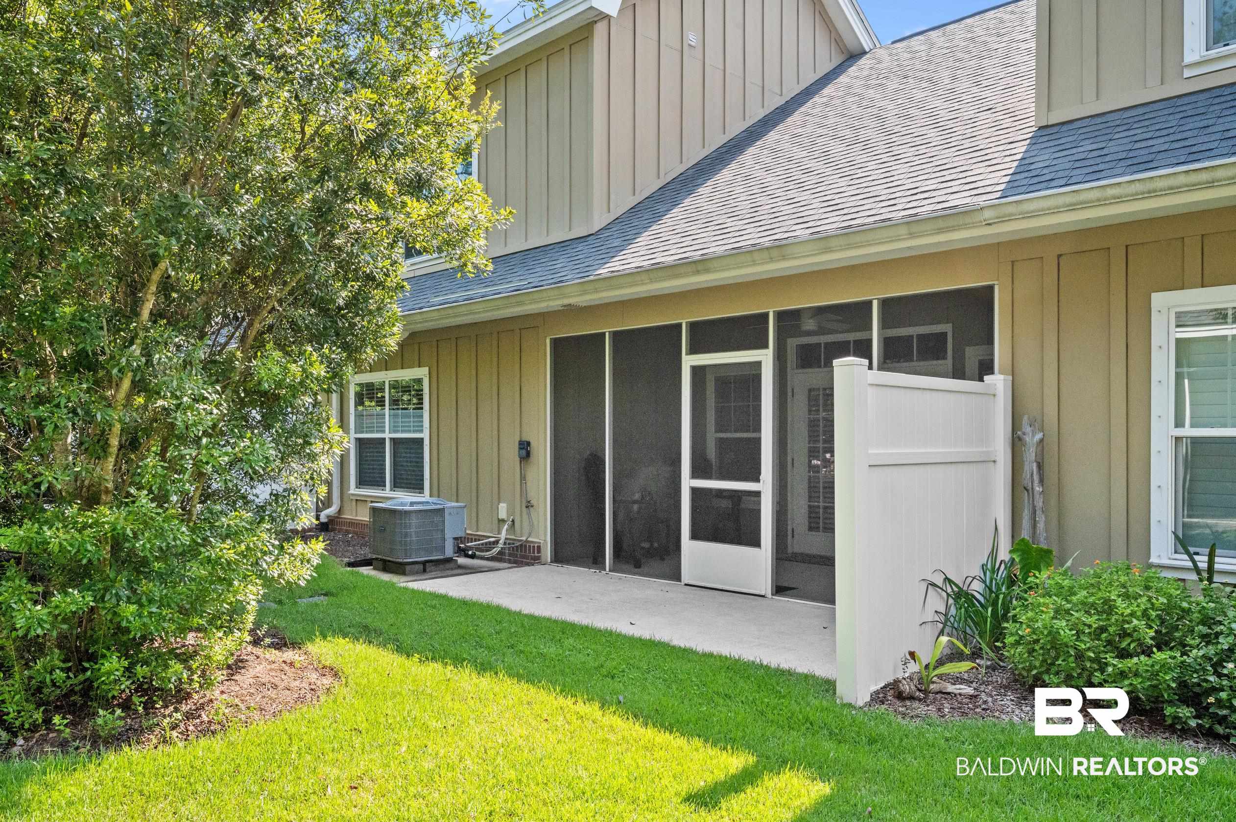 430 West Fort Morgan Road, Unit 1902 Gulf Shores, AL 36542 - Photo 40 of 59 Back of house featuring a patio area, a lawn, and central AC unit