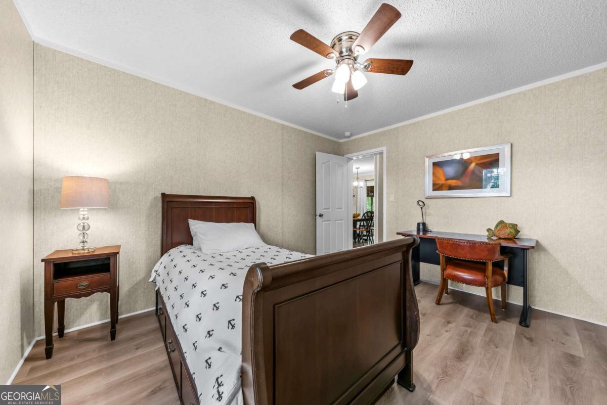 194 Phillips Road Eatonton, GA 31024 - Photo 29 of 57 a bedroom with a bed and a chandelier