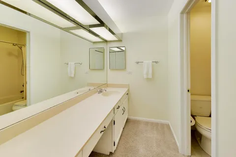 a spacious bathroom with a double vanity sink and mirror