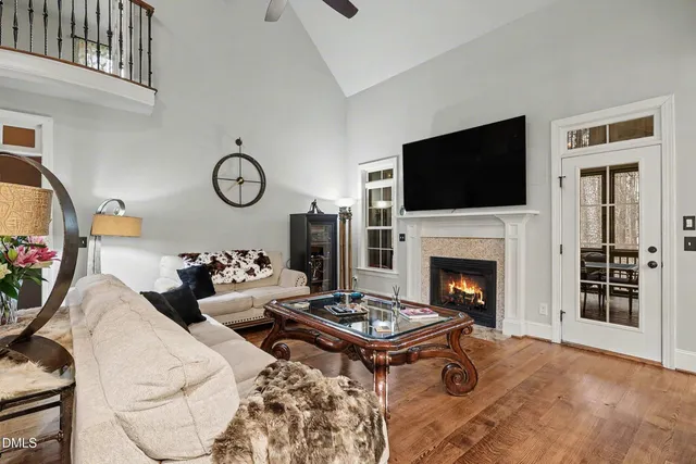 a dining room with wooden floor a chandelier a glass table and chairs