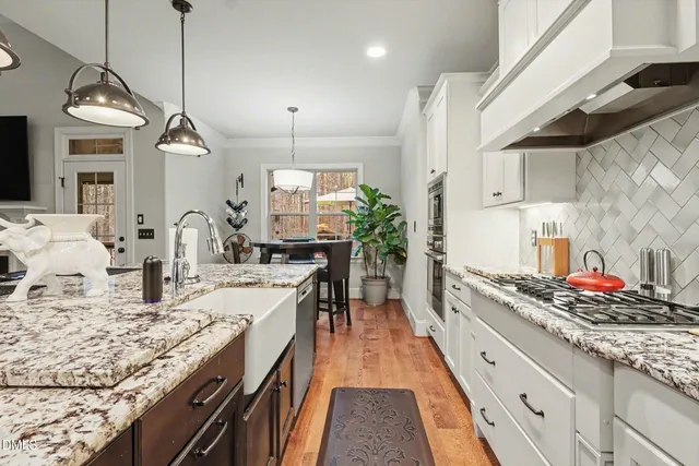 a dining room with furniture potted plants and wooden floor