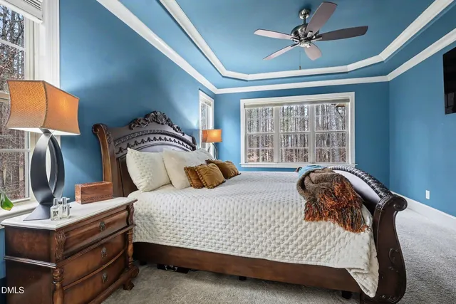 a bedroom with a bed a flat screen tv and a window