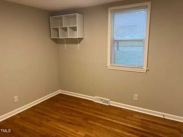 a view of a small space with wooden floor and a window