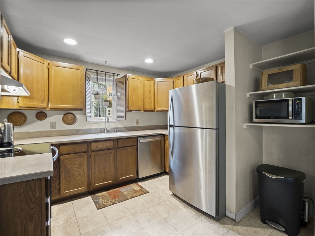 106 Lundberg Street, Unit 6 Lowell, MA 01852 - Photo 6 of 29 a kitchen with stainless steel appliances granite countertop a refrigerator a stove a sink and a microwave
