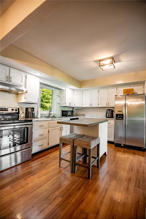 1010 South Keel Ridge Road Hermitage, PA 16148 - Photo 23 of 35 a kitchen with stainless steel appliances kitchen island granite countertop a stove a sink and a refrigerator with wooden floor