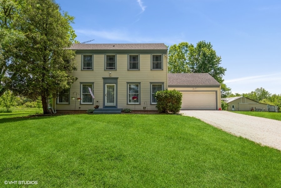 15817 Green Road Harvard, IL 60033 - Photo 1 of 25 a front view of a house with a garden and yard