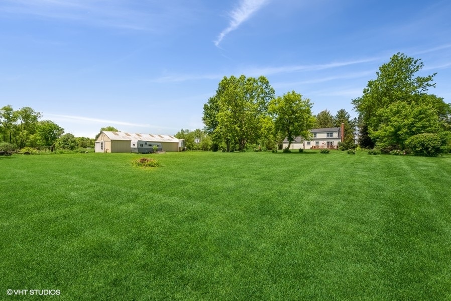 15817 Green Road Harvard, IL 60033 - Photo 22 of 25 a backyard of a house with lots of green space and garden