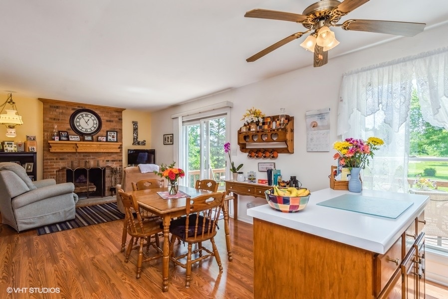 15817 Green Road Harvard, IL 60033 - Photo 5 of 25 a dining room with furniture a fireplace and a chandelier