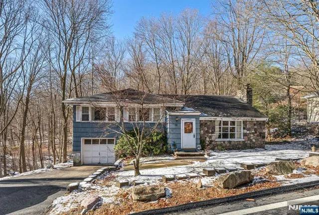 a front view of a house with a tree in it