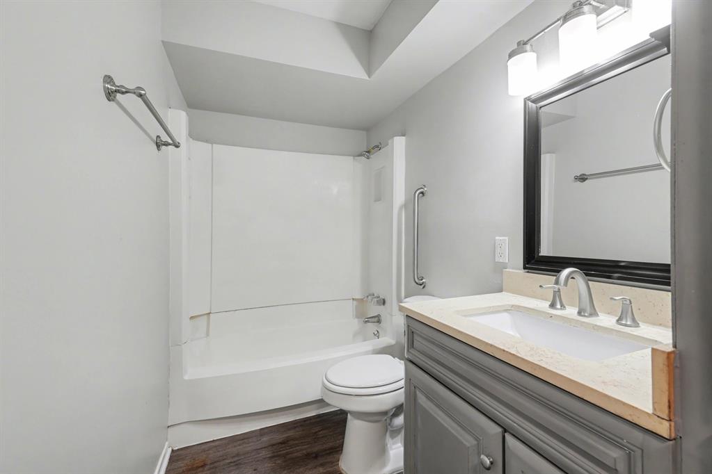 1321 North 7th Street Conroe, TX 77301 - Photo 13 of 17 a bathroom with a sink a toilet and a bathtub