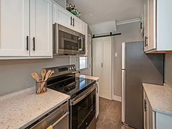 a kitchen with stainless steel appliances granite countertop a stove microwave and refrigerator