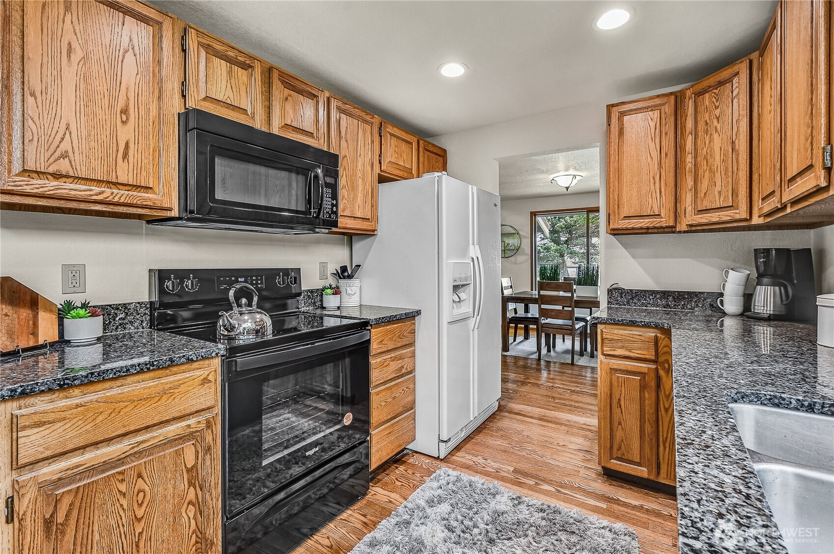 16901 Southeast 45th Street Bellevue, WA 98006 - Photo 15 of 29 a kitchen with granite countertop wooden cabinets a stove top oven and stainless steel appliances