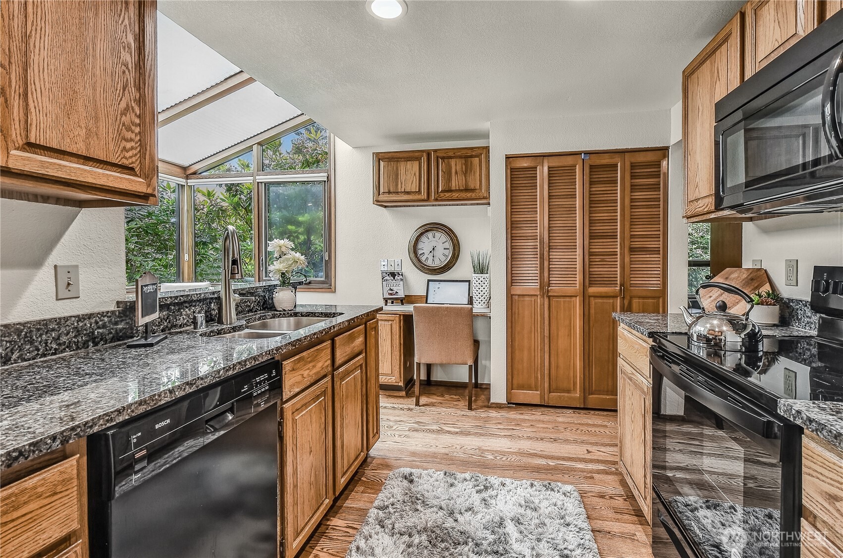 16901 Southeast 45th Street Bellevue, WA 98006 - Photo 16 of 29 a kitchen with stainless steel appliances granite countertop a stove a sink and a microwave