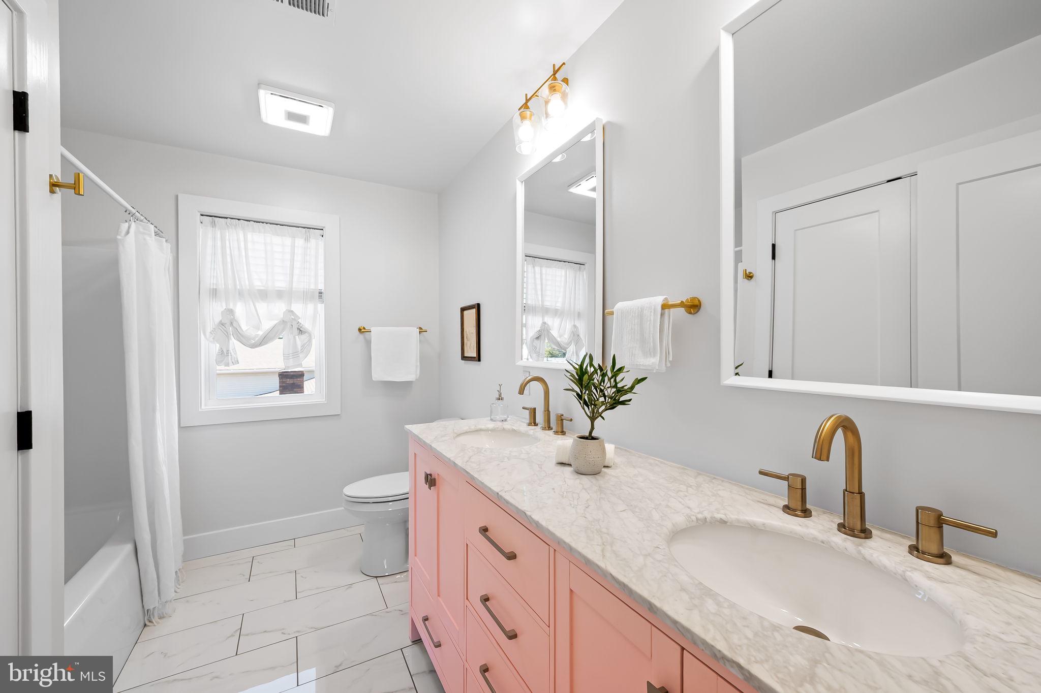 7321 Chesapeake Road Baltimore, MD 21220 - Photo 24 of 60 a bathroom with a granite countertop sink mirror vanity bathtub and a toilet