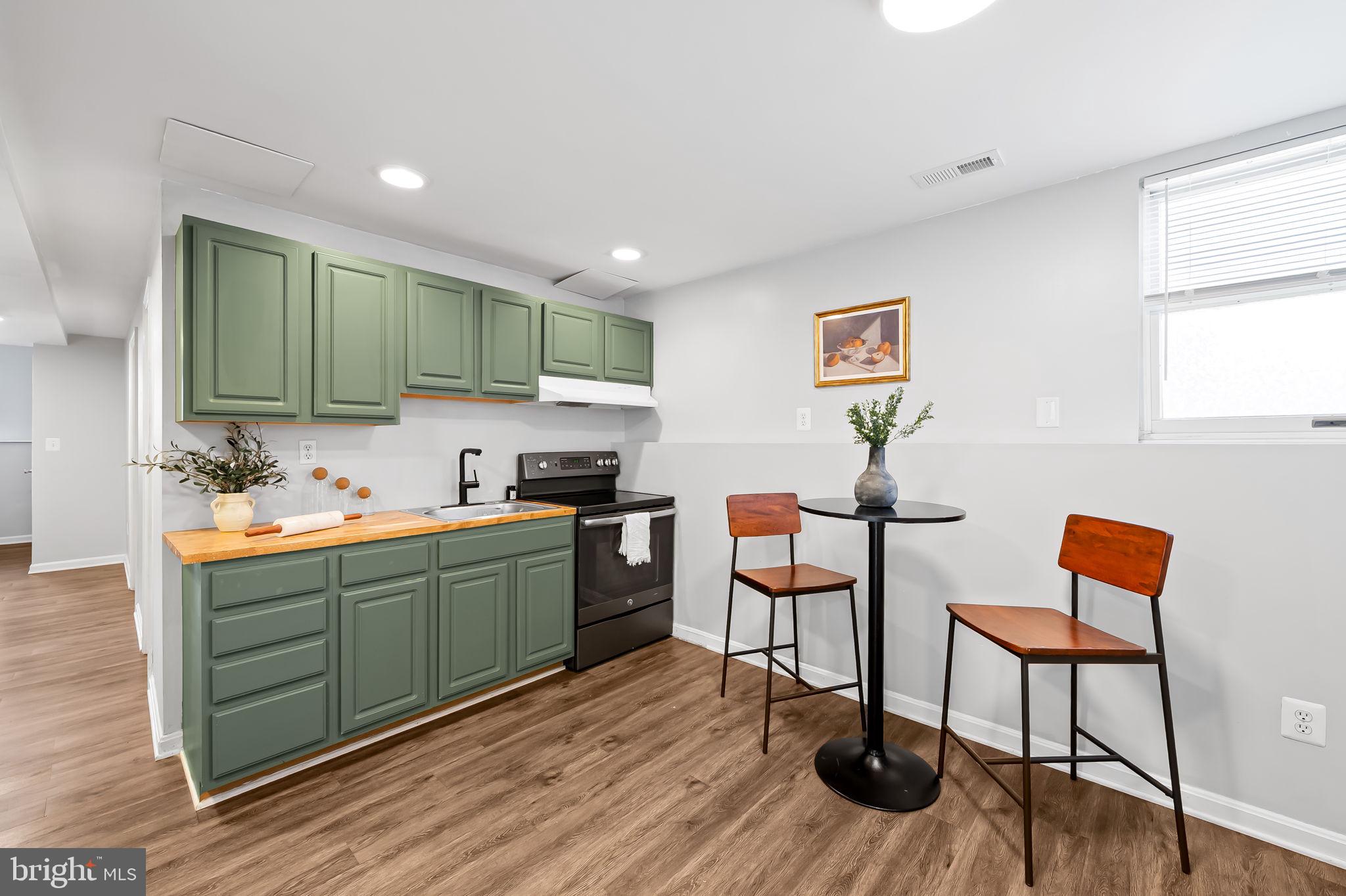 7321 Chesapeake Road Baltimore, MD 21220 - Photo 38 of 60 a kitchen with stainless steel appliances dining table chairs and wooden floor