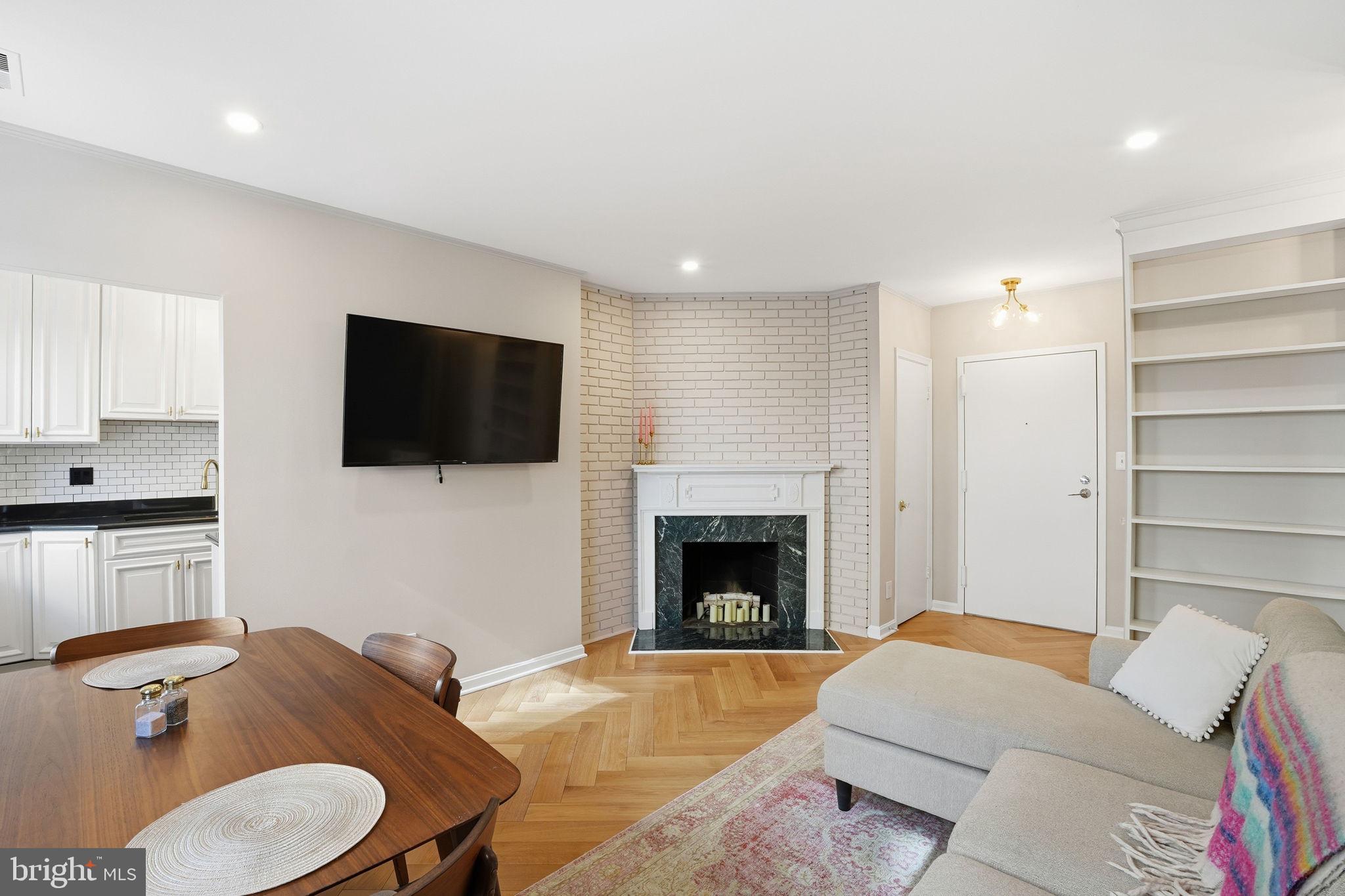 2001 16th Street Northwest, Unit 202 Washington, DC 20009 - Photo 4 of 20 a living room with furniture a fireplace and a flat screen tv