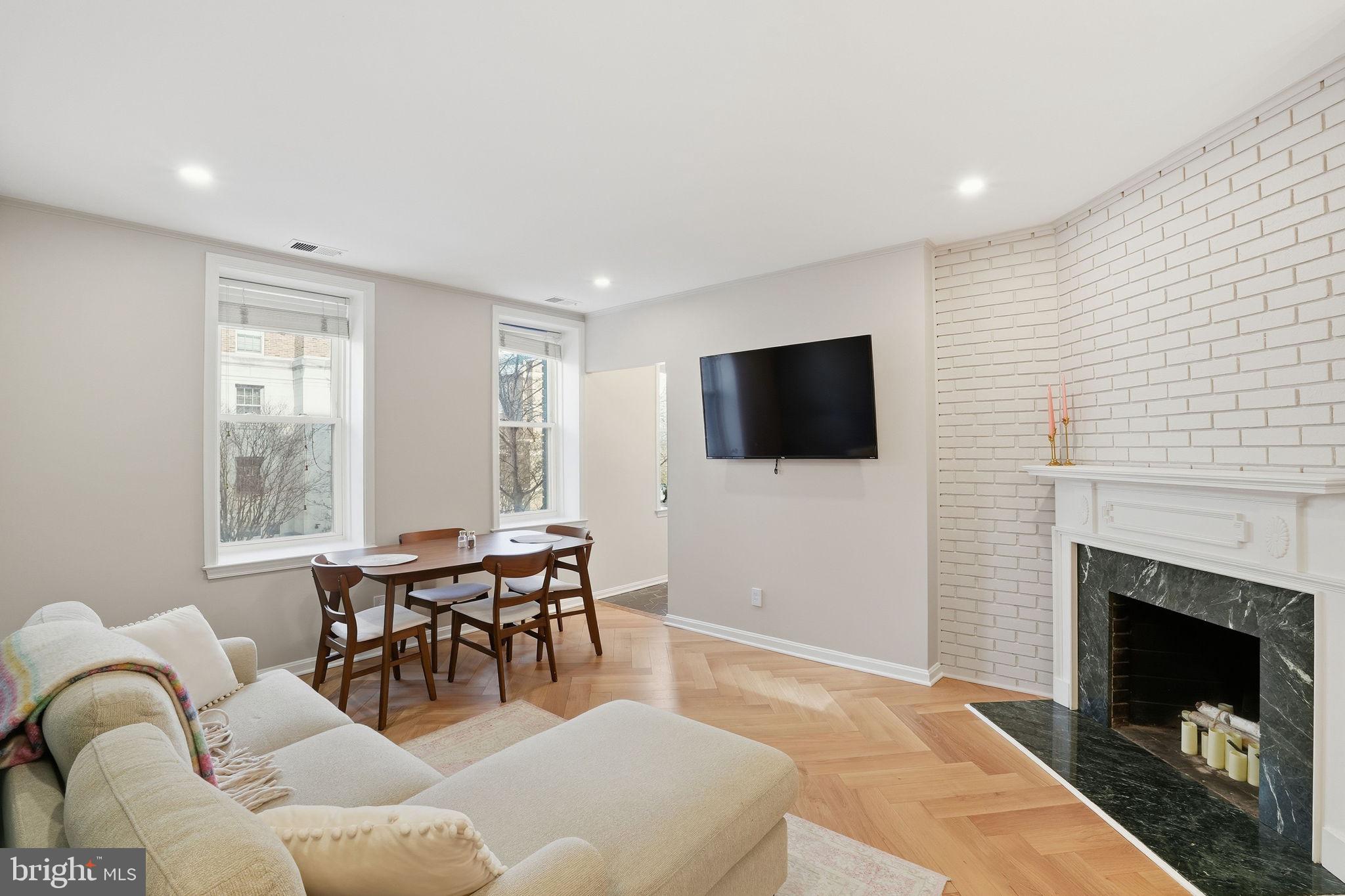 2001 16th Street Northwest, Unit 202 Washington, DC 20009 - Photo 5 of 20 a living room with furniture a fireplace and a flat screen tv