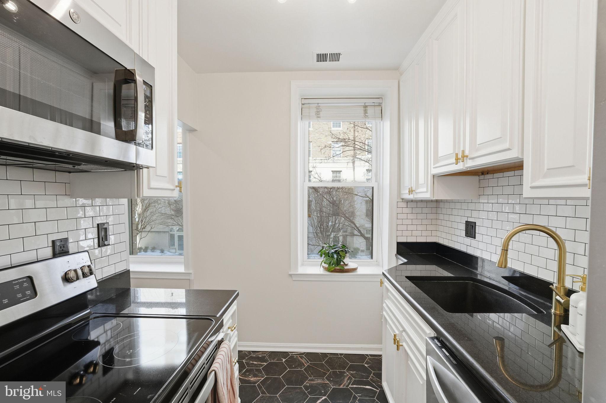 2001 16th Street Northwest, Unit 202 Washington, DC 20009 - Photo 6 of 20 a kitchen with granite countertop a stove and a microwave