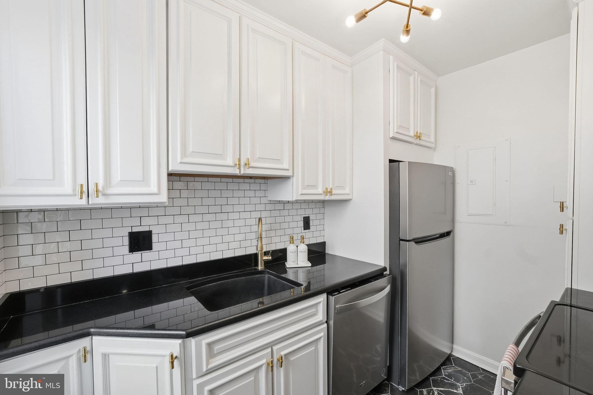 2001 16th Street Northwest, Unit 202 Washington, DC 20009 - Photo 7 of 20 a kitchen with white cabinets and stainless steel appliances