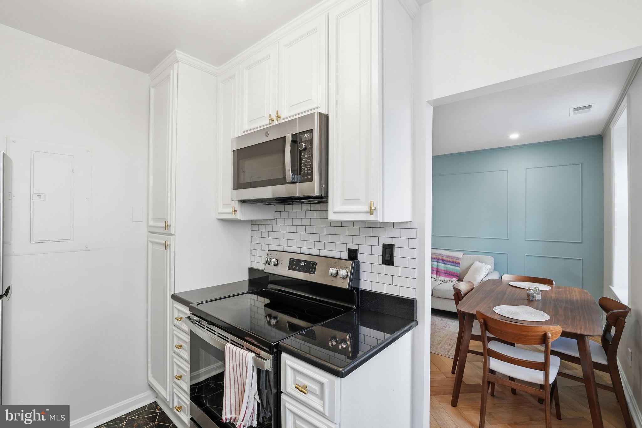 2001 16th Street Northwest, Unit 202 Washington, DC 20009 - Photo 8 of 20 a kitchen with stainless steel appliances a stove a microwave a sink and white cabinets