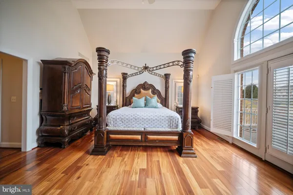 a bedroom with a large bed and a chandelier