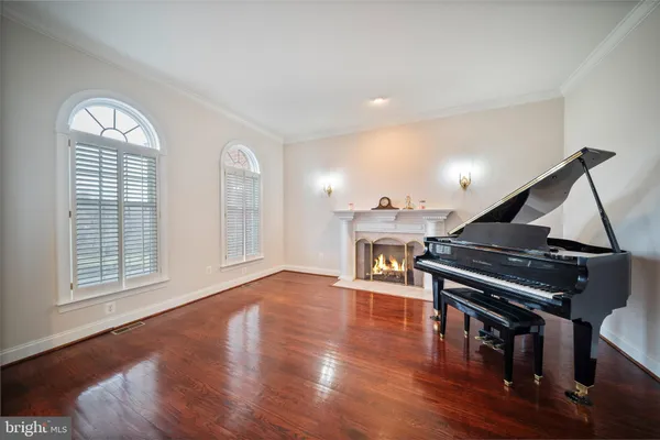 a living room with furniture a large window and wooden floor