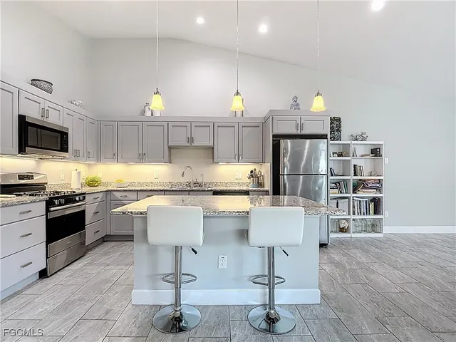 a kitchen with cabinets and chairs