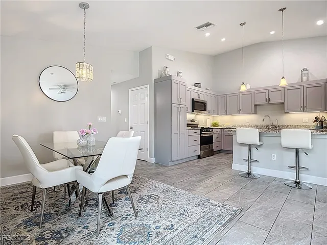 a living room with furniture kitchen view and a chandelier