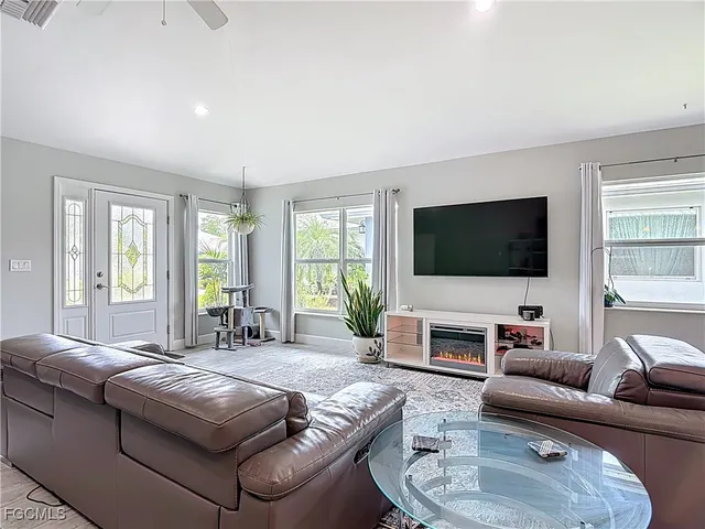 a living room with furniture flat screen tv and a large window