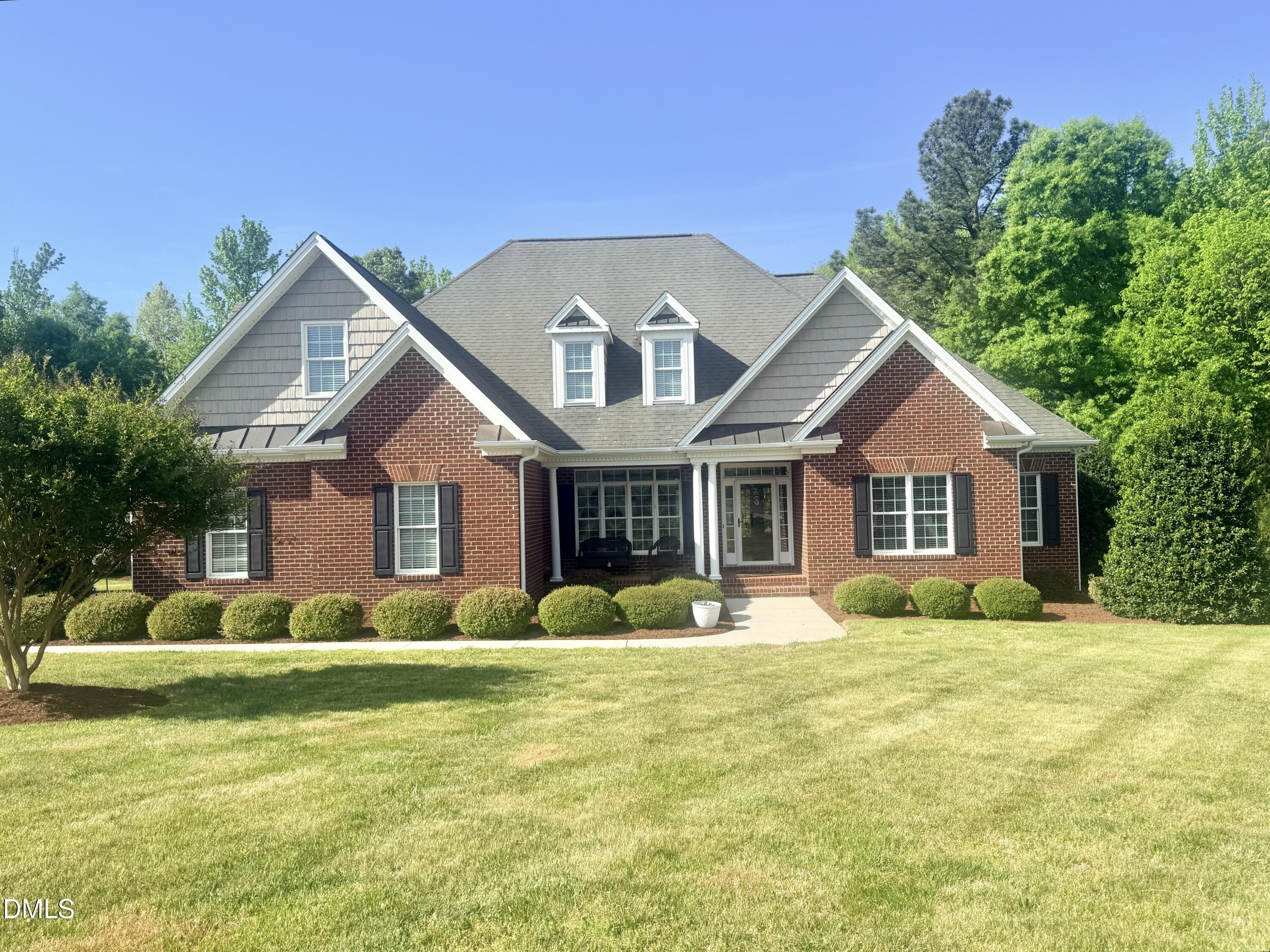 a front view of house with yard and green space