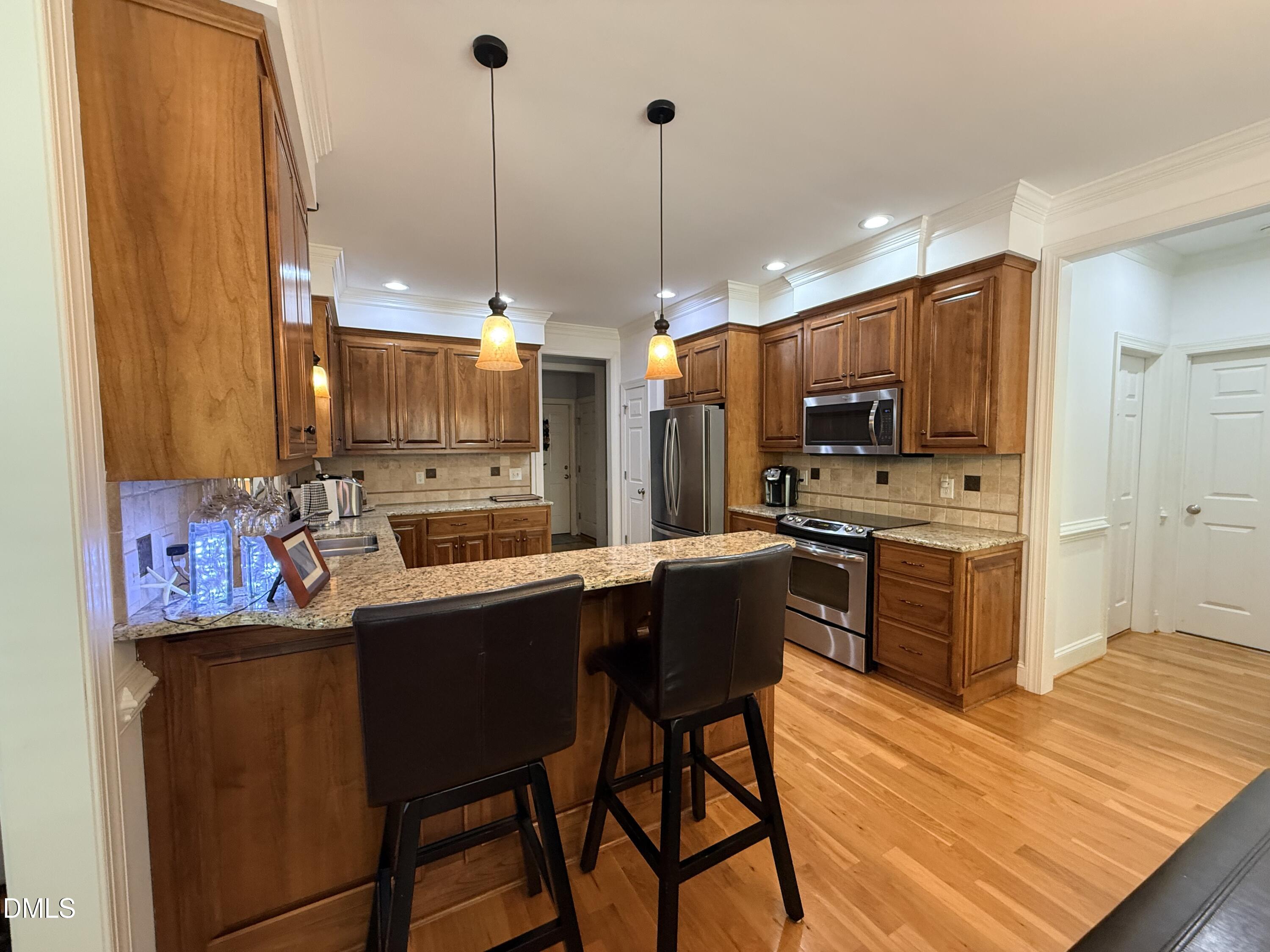 217 Clearwater Drive Roxboro, NC 27574 - Photo 19 of 57 a kitchen with stainless steel appliances granite countertop a sink a stove a refrigerator cabinets and chairs