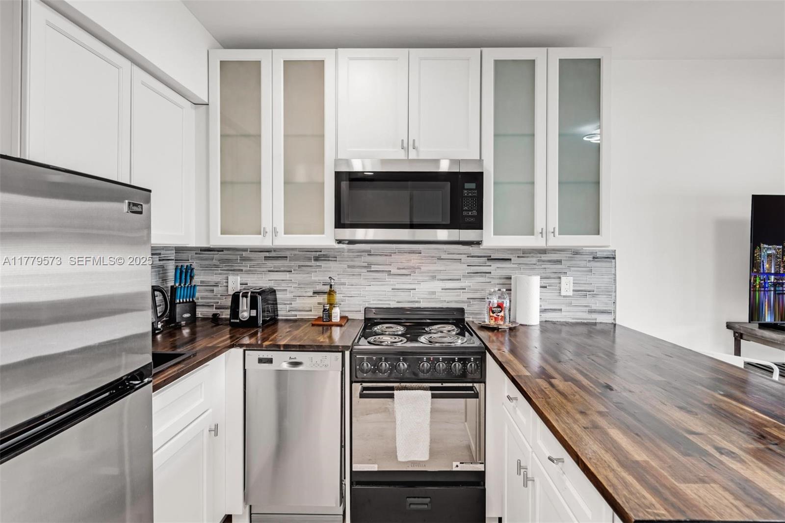 1630 Southwest 4th Avenue, Unit 2 Fort Lauderdale, FL 33315 - Photo 5 of 8 a kitchen with cabinets stainless steel appliances and a counter space
