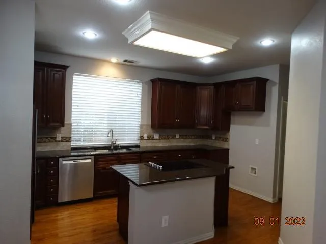 a kitchen with stainless steel appliances granite countertop a sink stove and cabinets
