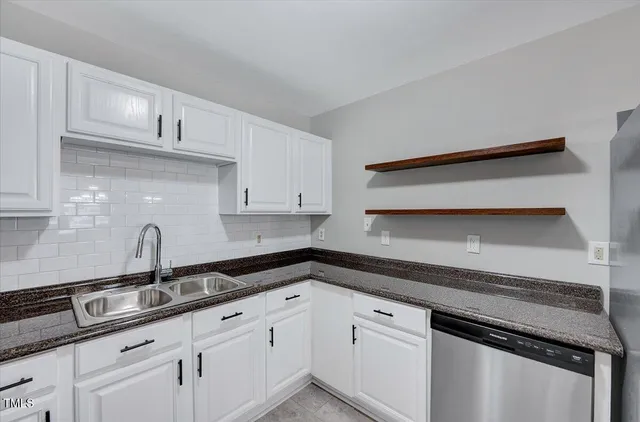 a kitchen with granite countertop a sink and cabinets