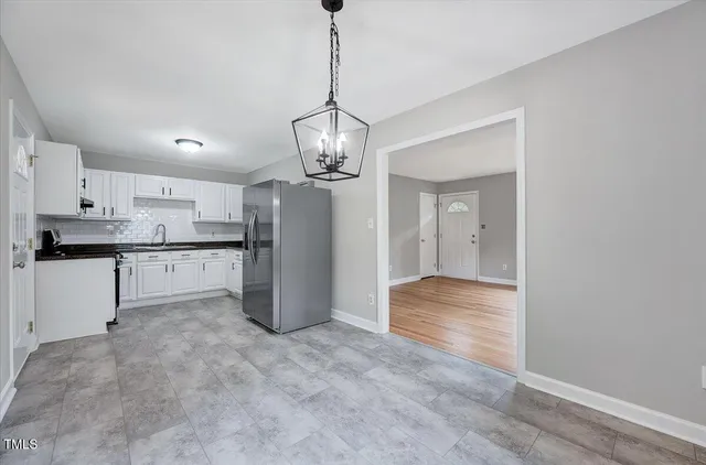 a view of a kitchen with refrigerator and wooden floor