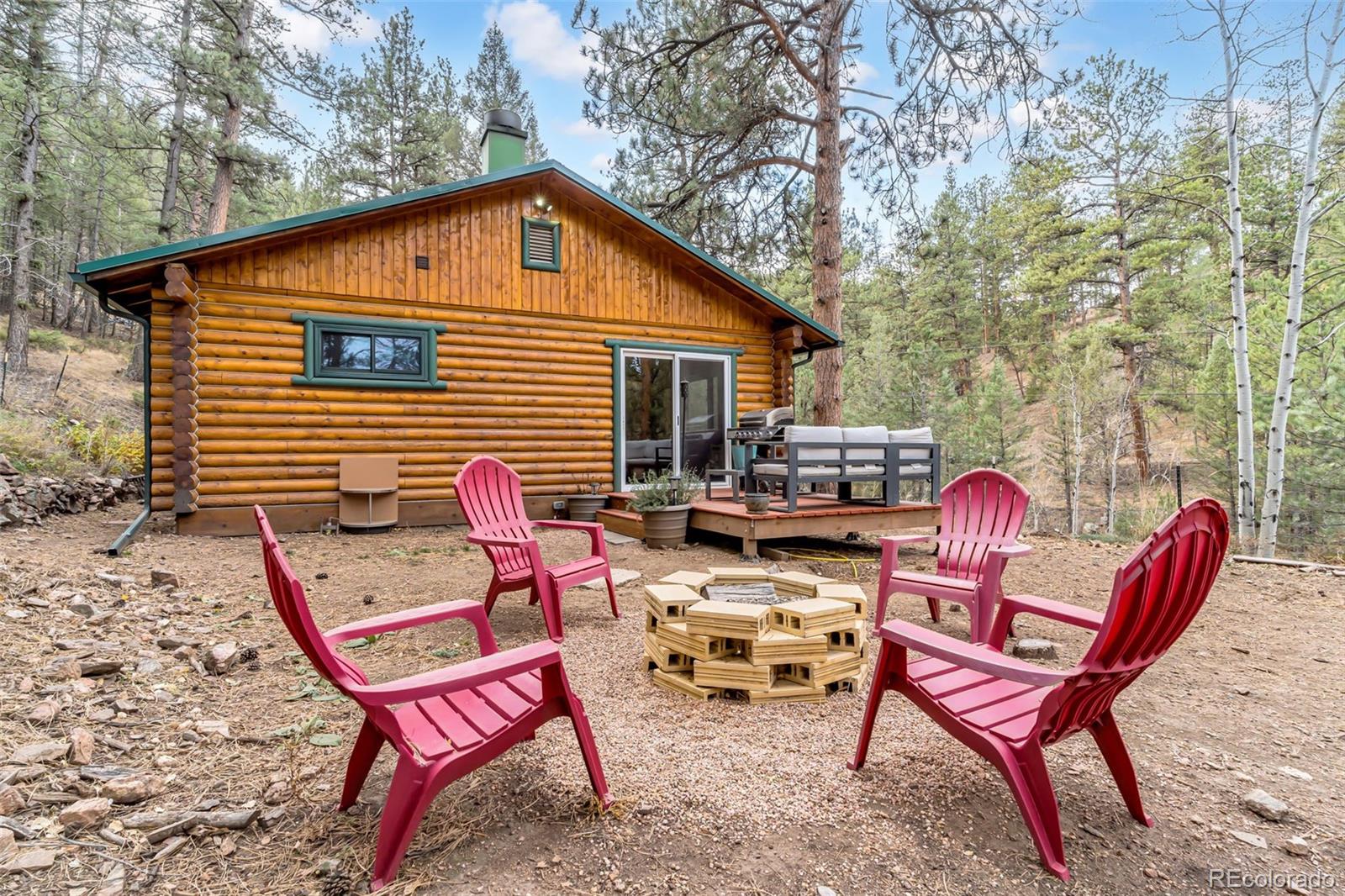 14601 South Elk Creek Road Pine, CO 80470 - Photo 20 of 26 a backyard of a house with table and chairs