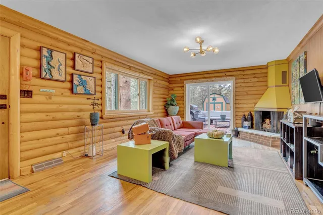 a living room with fireplace furniture and a large window