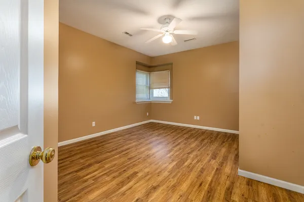 a view of an empty room with wooden floor