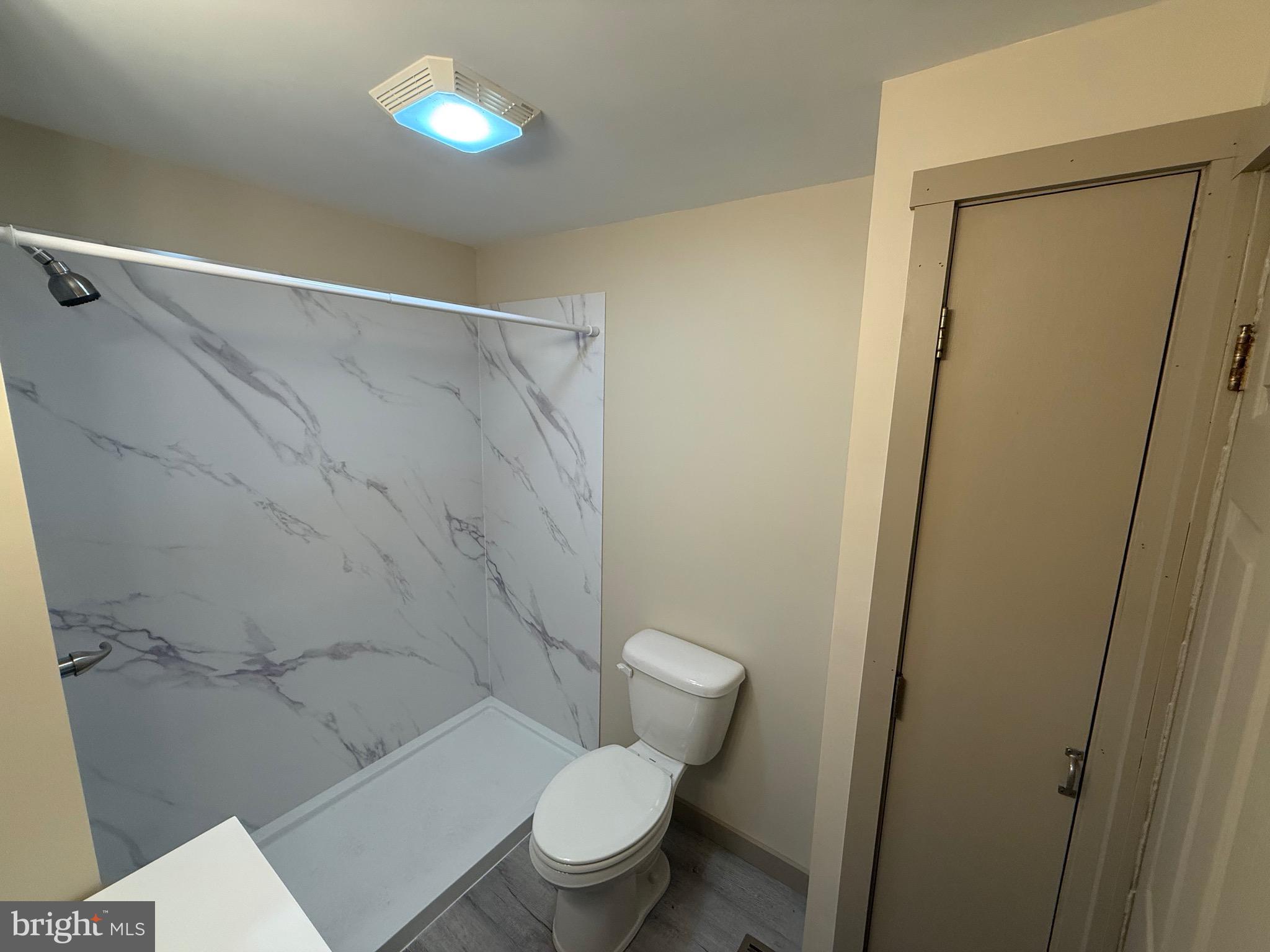 9505 Main Street Huntingdon, PA 16652 - Photo 23 of 72 a white toilet sitting next to a bathroom sink and vanity