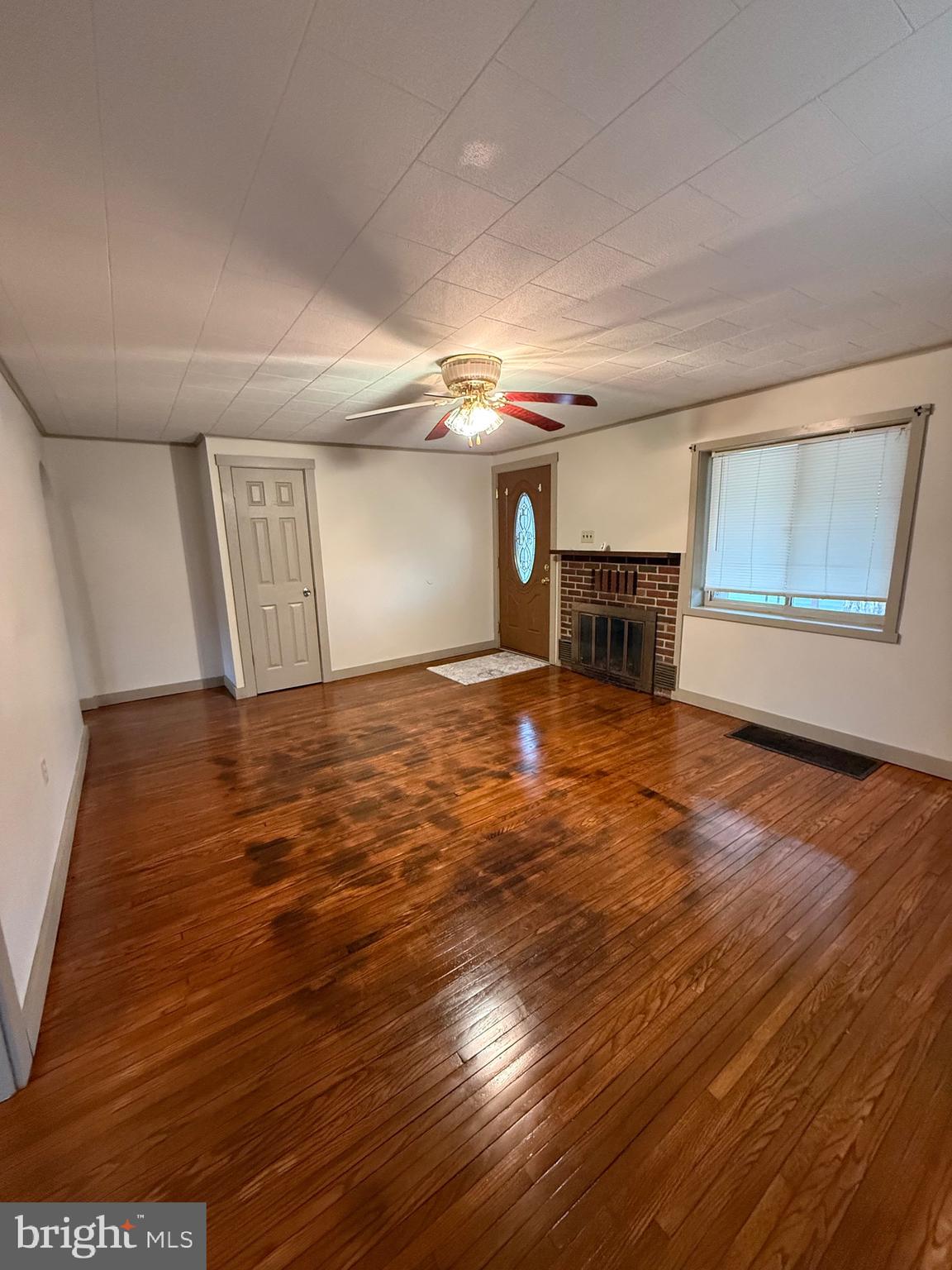 9505 Main Street Huntingdon, PA 16652 - Photo 60 of 72 an empty room with wooden floor fireplace and windows