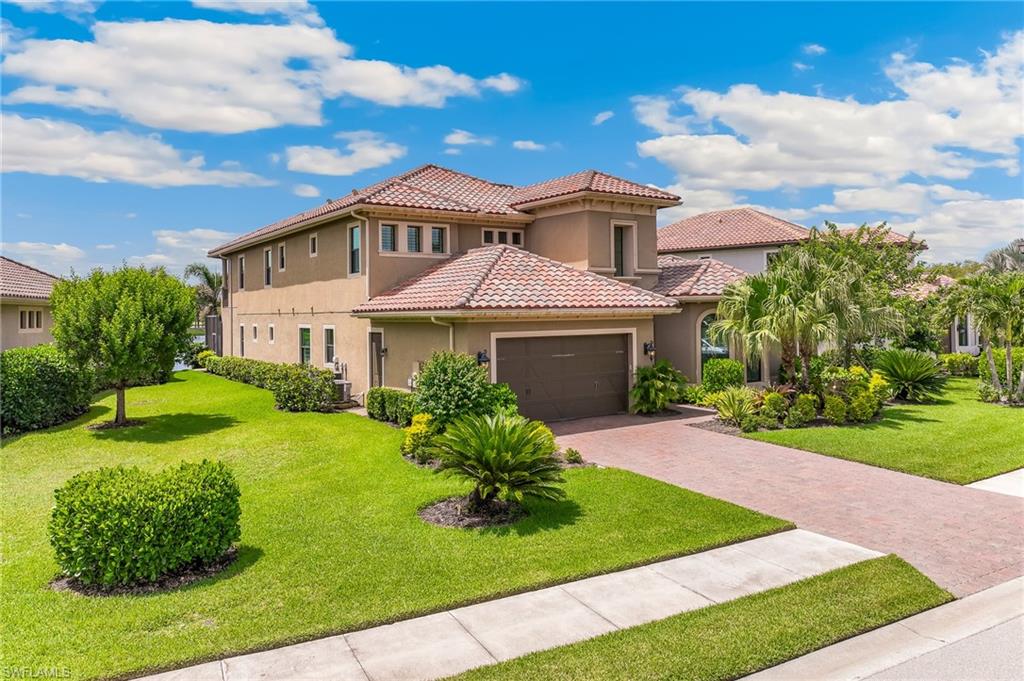 12749 Dundee Lane Naples, FL 34120 - Photo 4 of 45 a front view of a house with a garden