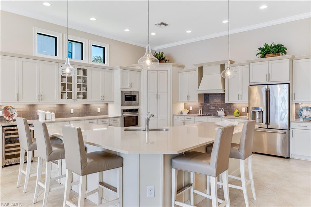 12749 Dundee Lane Naples, FL 34120 - Photo 7 of 45 a kitchen with stainless steel appliances kitchen island granite countertop a kitchen island and chairs in it